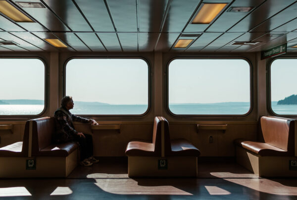 Imagen de una persona en un ferry, mirando por la ventana el mar.