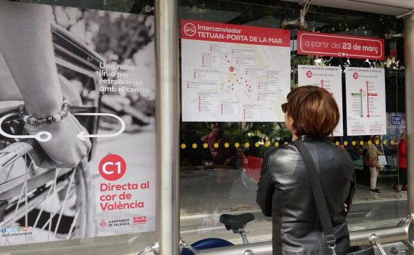 Imagen: señora observando los carteles colocados en la marquesina de bus