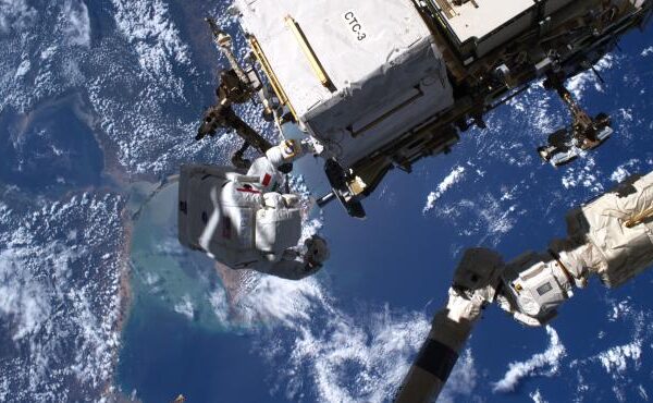 Astronautas en el espacio reparando un dispositivo espacial.