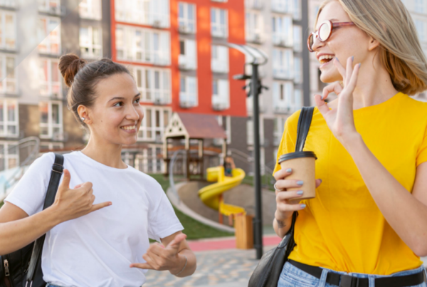 Fotografía de dos mujeres jóvenes hablando con lengua de signos