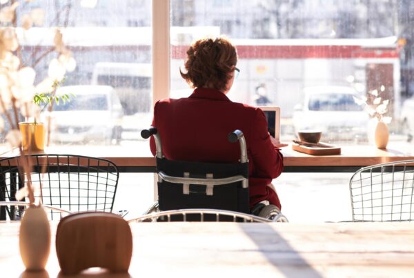 Mujer en silla de ruedas trabajando con un ordenador portátil.