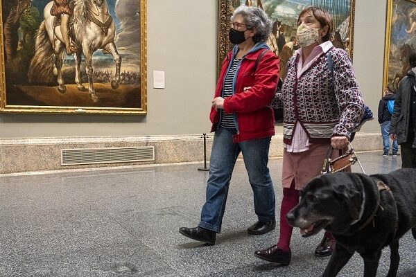Una mujer ciega visitando un museo junto a su perro guía