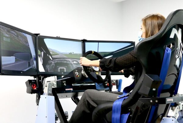 Fotografía de una mujer joven probando el simulador de conducción