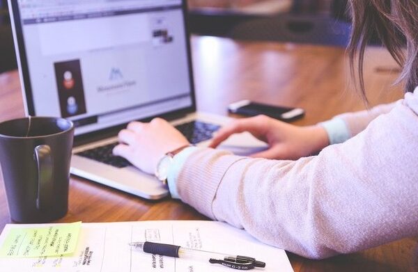 Mujer joven escribiendo en un ordenador portátil