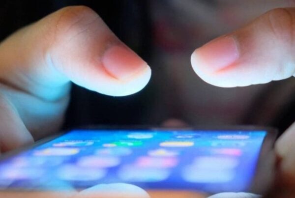Manos de persona joven utilizando un teléfono móvil