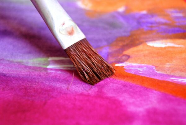 Pincel sobre un lienzo con muchos colores
