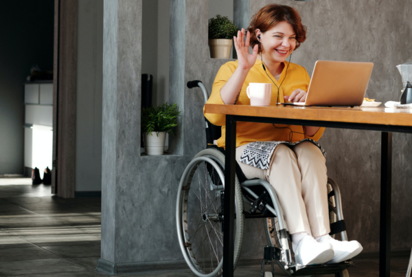 Fotografía de una mujer joven en silla de ruedas trabajando con su ordenador portátil