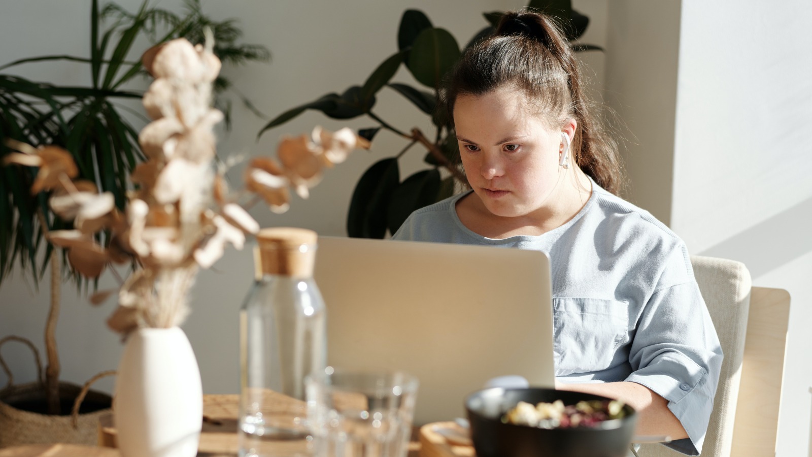 Mujer joven con Síndrome de Down trabaja con un ordenador portátil