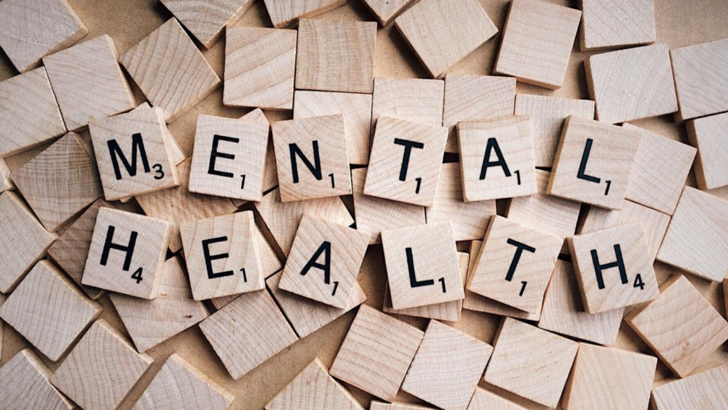 Fotografía de piezas de juego cuadradas de madera con letras que forman las palabras Mental Health