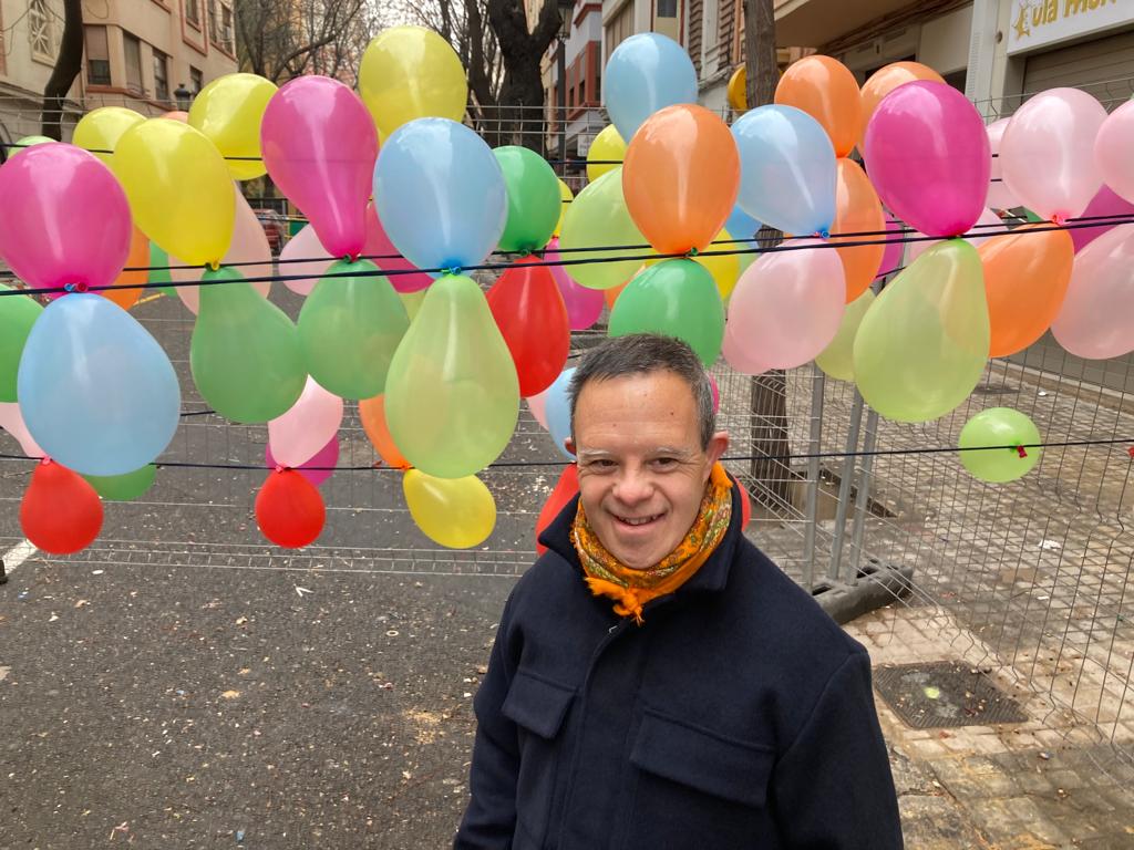 José Miguel, un hombre de 51 años con Síndrome de Down es el conductor del curso sobre tecnología para la inclusión. En la imagen aparece con un fondo de globos hinchables de colores.