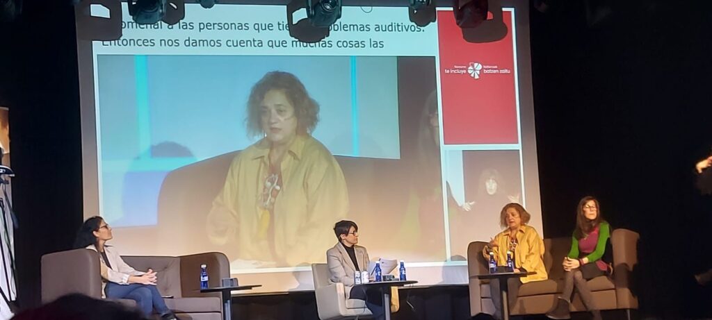La directora de dicatic en la pantalla del salon donde se celebra la jornada de Pamplona.