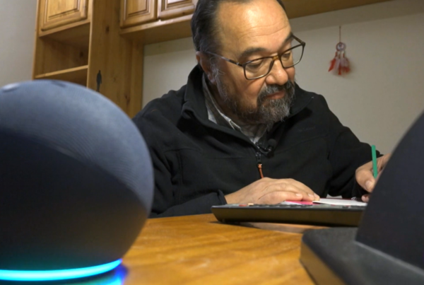 Dispositivo alexa en primer plano y un hombre con discapacidad escribiendo en su casa inteligente para salvar la brecha digital