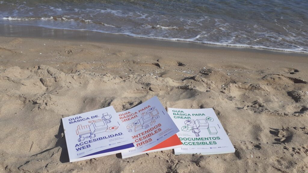 fotografía de las tres guias dicatic sobre la arena de la playa, muy cerca del agua