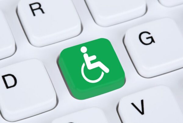 tecla verde en el teclado de un ordenador con el símbolo de una persona en silla de ruedas, en blanco