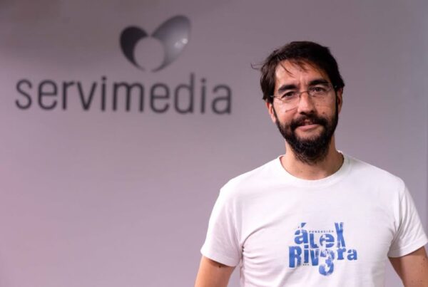Fotografía del fundador de la Fundación Alex Rivera, Carlos Rivera, durante su entrevista para servimedia. Al fondo, el logo de la agencia