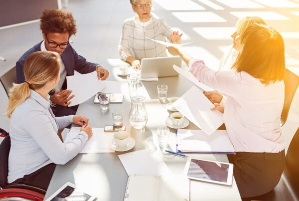 imagen de recurso de un grupo de personas trabajando. Una de ellas, mujer joven, está en silla de ruedas