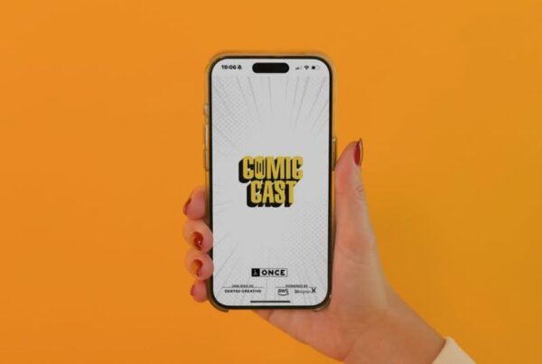 una mano de mujer, con las uñas pintadas, sostiene un teléfono móvil en el que está activa la aplicación comiccast.
