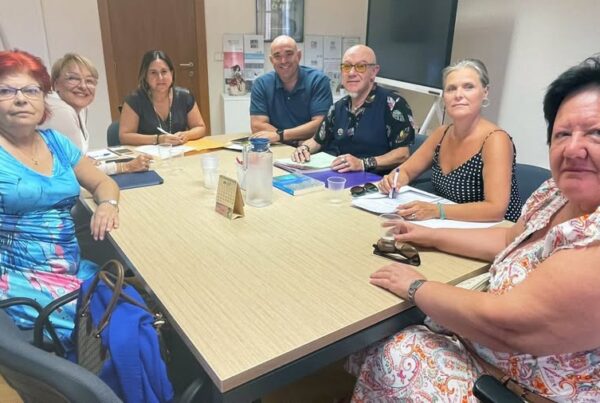 fotografía realizada durante la reunión de representantes del CERMI CV con representantes de la Conselleria de Eduación. Son siete personas, cinco mujeres y dos hombres, sentadas alrededor de una mesa de trabajo y mirando a la cámara.