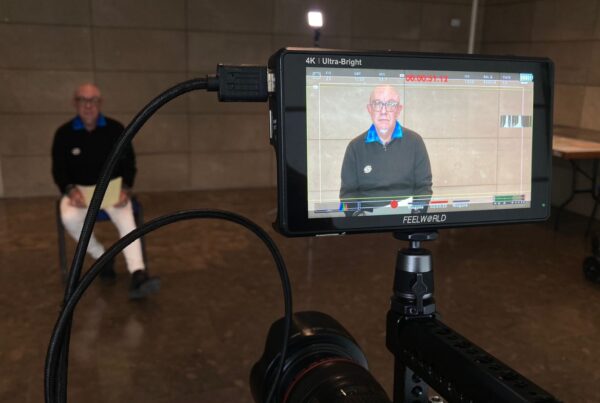 fotografía de Luis durante la grabación. Está sentado al fondo y se le ve a través del visor de la cámara