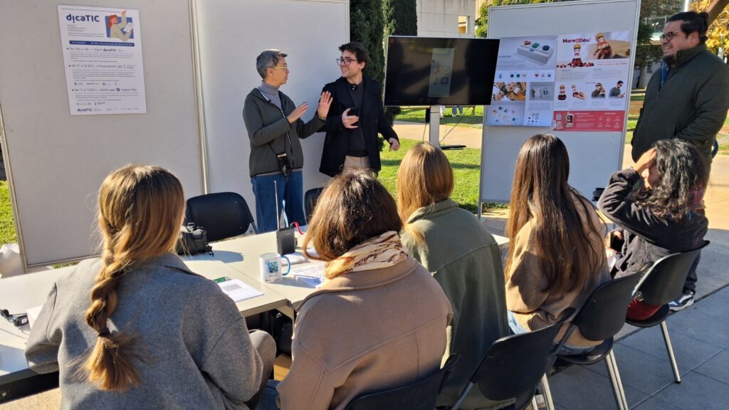 El responsable de la empresa play and go explica la nueva app del campus escultórico de la upv a varias estudiantes
