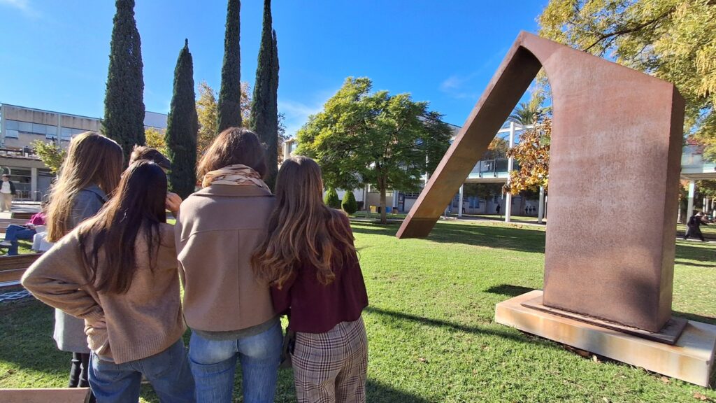 un grupo de estudiantes visita una de las esculturas del campus con la nueva app accesible