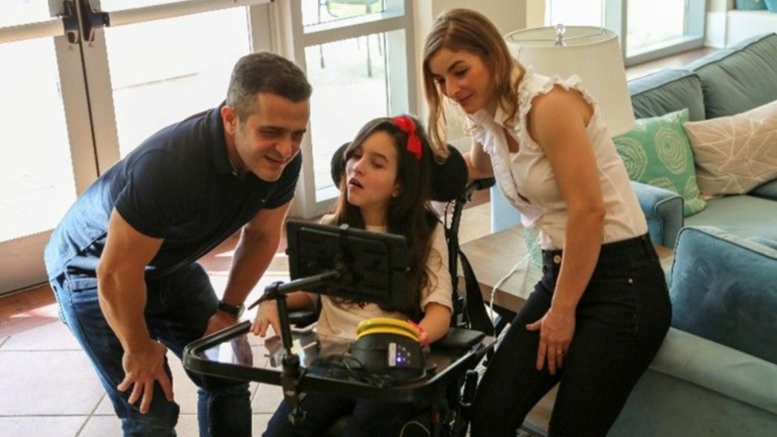 fotografía de una familia, el padre, la madre y la hija adolescente, que usa silla de ruedas