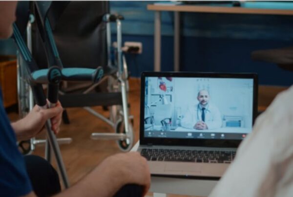 imagen de un ordenador portátil con un médico hablando con pacientes con discapacidad
