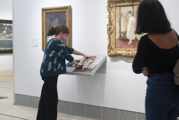 una mejor ciega explora con sus manos una de las réplicas en relieve de un cuadro.