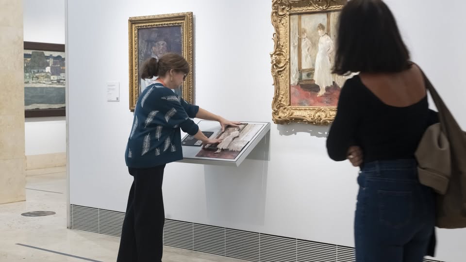 una mejor ciega explora con sus manos una de las réplicas en relieve de un cuadro.
