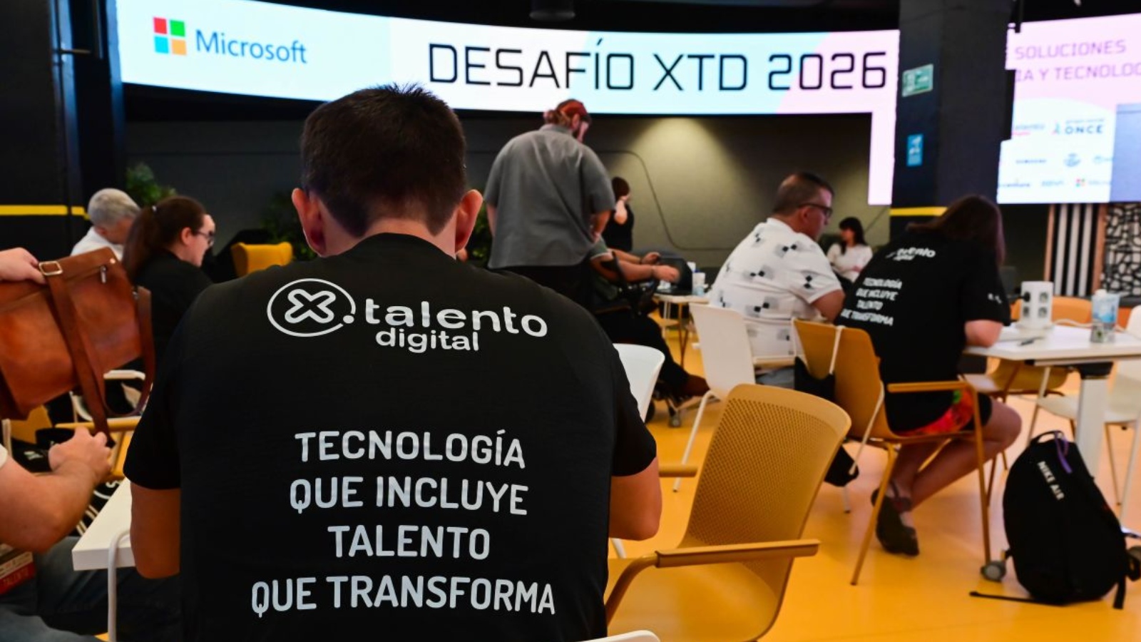 fotografía de la jornada, con varios participantes trabajando en grupos en diferentes mesas