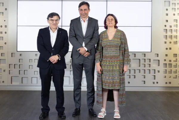 Tres personas posan juntas en un evento profesional de accesibilidad digital UPV, de pie frente a una pared blanca con detalles arquitectónicos modernos.